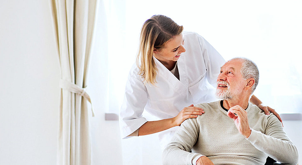 a nurse smiling while listening to her patient talking