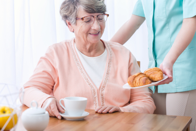 caregiver assisting senior to eat